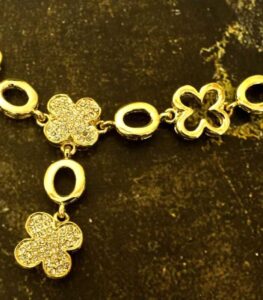 Clover Charm Necklace and Bracelet Set with gold-plated floral motifs and clear crystal accents from L’Africaine Boutique.