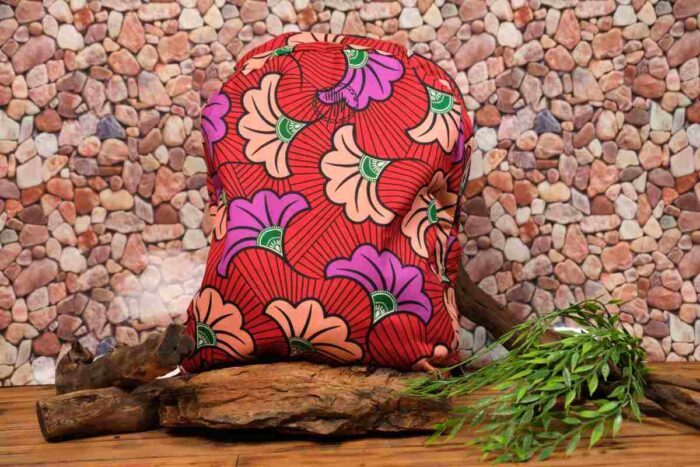 Flora Ankara Backpack with peach and violet floral motifs on a red background, accented with green details and L’Africaine Boutique logo.