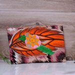 Desert Mirage Clutch featuring bold orange feather design and hand-beaded floral appliqué with sequins, inspired by the Vaal region.