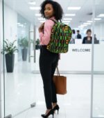 Kente Legacy Backpack with bold Ghanaian Kente patterns in green, gold, red, and black, featuring L’Africaine Boutique emblem.