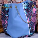Lilac Sky African Cinch Bag with soft blue-lilac panel, geometric Ankara print in pink, teal, and purple, and gold chain drawstring.