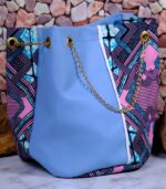 Lilac Sky African Cinch Bag with soft blue-lilac panel, geometric Ankara print in pink, teal, and purple, and gold chain drawstring.