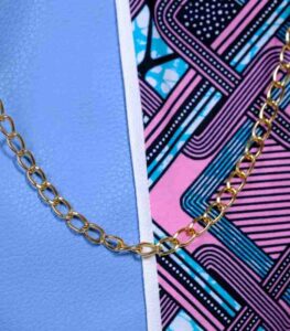 Lilac Sky African Cinch Bag with soft blue-lilac panel, geometric Ankara print in pink, teal, and purple, and gold chain drawstring.
