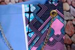 Lilac Sky African Cinch Bag with soft blue-lilac panel, geometric Ankara print in pink, teal, and purple, and gold chain drawstring.