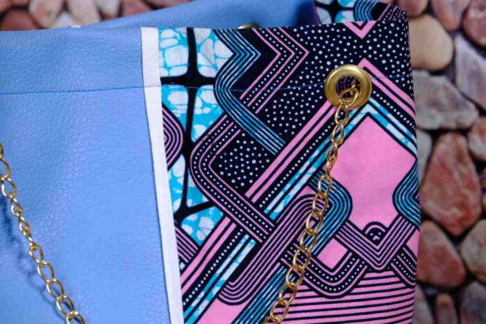 Lilac Sky African Cinch Bag with soft blue-lilac panel, geometric Ankara print in pink, teal, and purple, and gold chain drawstring.