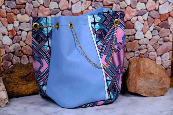 Lilac Sky African Cinch Bag with soft blue-lilac panel, geometric Ankara print in pink, teal, and purple, and gold chain drawstring.