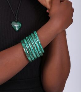 Stack of polished green malachite bangles with natural banding, symbolizing strength, healing, and transformation.