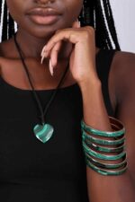 Stack of polished green malachite bangles with natural banding, symbolizing strength, healing, and transformation.