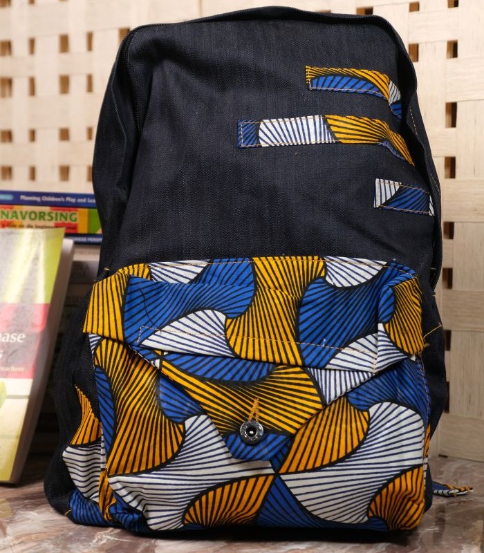 Midnight Geometry Ankara Backpack with black denim and geometric patterns in cobalt blue, golden yellow, and ivory, featuring L’Africaine Boutique logo.