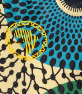 Orbit Ankara Backpack with bold circular motifs in yellow, green, red, and blue, featuring structured design and L’Africaine Boutique logo.
