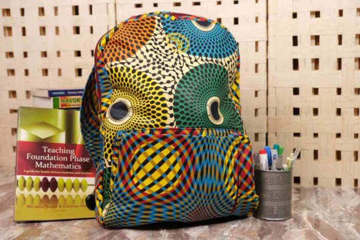 Orbit Ankara Backpack with bold circular motifs in yellow, green, red, and blue, featuring structured design and L’Africaine Boutique logo.