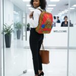 Regal Ankara Backpack with red canvas and intricate Ankara patterns in gold, green, and cobalt blue, featuring L’Africaine Boutique emblem.