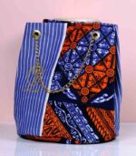 Sanaa African Cinch Bag made from Ankara fabric with blue pinstripes, orange and navy “L’Africaine” motif, and gold chain strap.