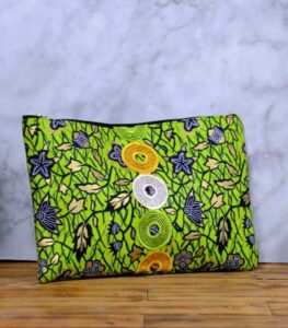 The Aura African Clutch in green Ankara fabric with floral and leafy print, featuring yellow, lime, and white embroidered sequin rings.