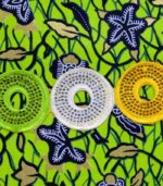 The Aura African Clutch in green Ankara fabric with floral and leafy print, featuring yellow, lime, and white embroidered sequin rings.