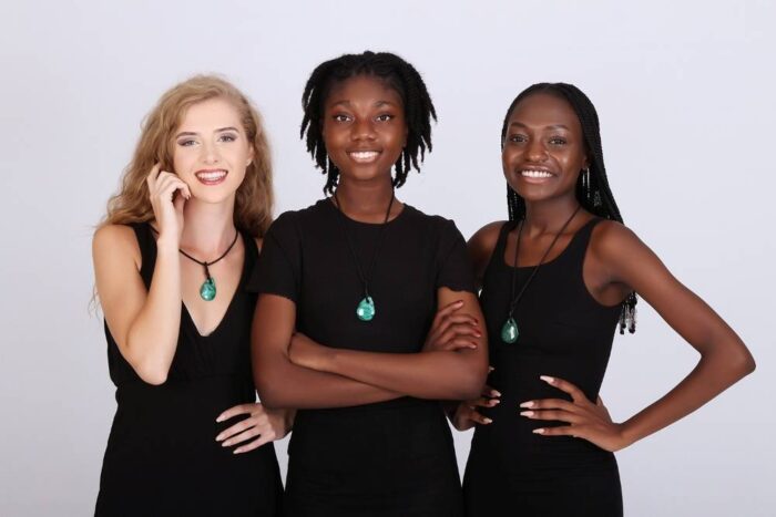 Teardrop-shaped green malachite pendant with natural banding on a black cord, symbolizing healing and emotional release.