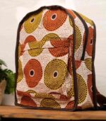 Sola Backpack with vibrant African wax print featuring concentric circles in orange, yellow, terracotta, and cream on durable canvas.