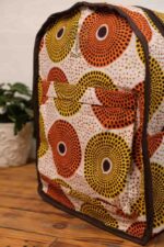 Sola Backpack with vibrant African wax print featuring concentric circles in orange, yellow, terracotta, and cream on durable canvas.