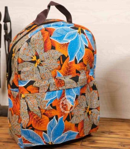 Tropical Bloom Backpack with vivid blue petals and fiery orange leaves on a grey and black background, featuring L’Africaine Boutique logo.