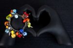 African Love bracelet with crimson, emerald, gold, and sapphire glass beads featuring dotted and rippled accents from L’Africaine Boutique.