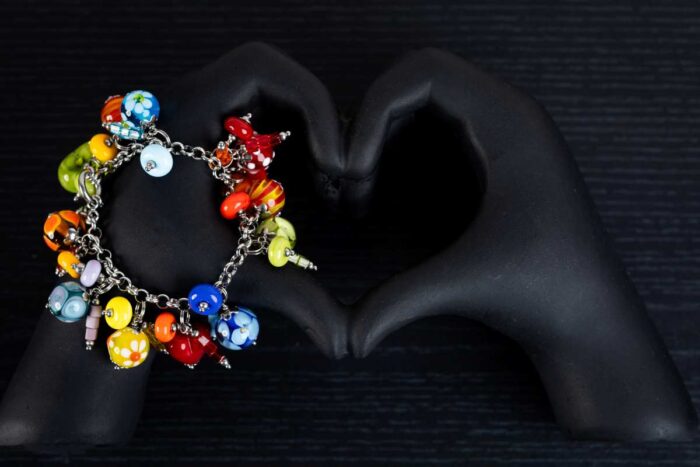 African Love bracelet with crimson, emerald, gold, and sapphire glass beads featuring dotted and rippled accents from L’Africaine Boutique.