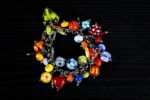 African Love bracelet with crimson, emerald, gold, and sapphire glass beads featuring dotted and rippled accents from L’Africaine Boutique.
