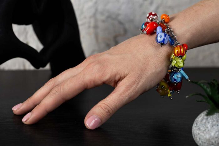 African Love bracelet with crimson, emerald, gold, and sapphire glass beads featuring dotted and rippled accents from L’Africaine Boutique.
