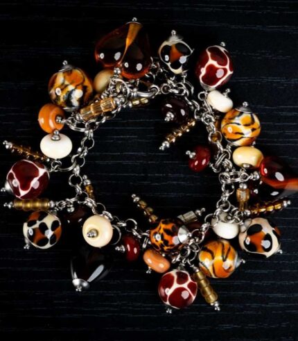 Animal Print bracelet with amber, cream, and brown glass beads featuring spotted and swirling patterns from L’Africaine Boutique.