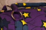 ankara star print handbag in deep purple and navy Ankara wax fabric with bold yellow and black star patterns, gold rings, and top zipper closure.