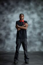 Black & Red Polo shirt with bold red collar and sleeve accents, featuring embroidered L’Africaine Boutique logo on the chest.