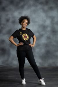 Floral Burst Tee with mandala-style flower appliqué in yellow, white, and red, accented by rhinestones on black cotton from L’Africaine Boutique.