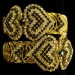 Gold-Plated Heart Bangles with woven heart-shaped patterns and rows of sparkling stones from L’Africaine Boutique.