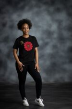 Black tee with bold red Ankara-inspired floral motif and golden detailing at the center from L’Africaine Boutique.