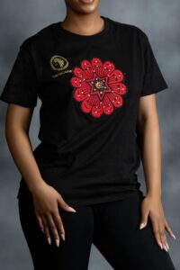 Black tee with bold red Ankara-inspired floral motif and golden detailing at the center from L’Africaine Boutique.