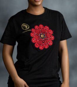 Black tee with bold red Ankara-inspired floral motif and golden detailing at the center from L’Africaine Boutique.