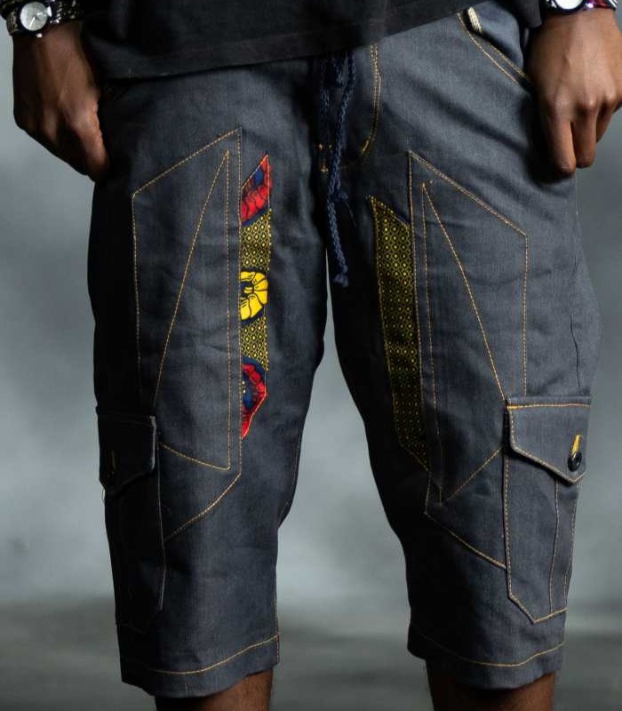 Statement Patch Jorts in dark-wash denim with bold red and yellow patterned side patches from L’Africaine Boutique.