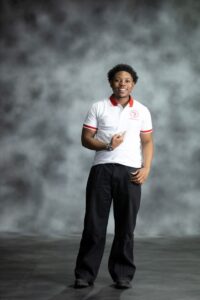 White Fire Polo shirt with red collar and sleeve accents, featuring embroidered L’Africaine Boutique logo on the chest.