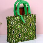 ankara emerald wave handbag in green and gold Ankara wax fabric with wave-like and teardrop motifs, padded handles, and structured boxy silhouette.