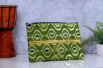 ankara gold wave clutch by L’Africaine Boutique—crafted from wax fabric with gold and green wave print, black detailing, and gold zipper for day or night.