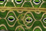 ankara gold wave clutch by L’Africaine Boutique—crafted from wax fabric with gold and green wave print, black detailing, and gold zipper for day or night.