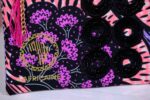 ankara midnight bloom clutch in purple, pink, and black Ankara wax fabric with hand-embroidered sequin rings, gold logo, and pink tassel zipper accent.