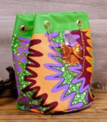 ankara sequin bucket bag in multicolor Ankara wax fabric with zigzag print, green faux leather trim, gold chain strap, and sequin bow embellishment.