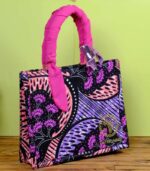 ankara star sequin handbag in pink and blue Ankara wax fabric with bold star motifs, padded handles, solid frame, and shimmering sequin bow.