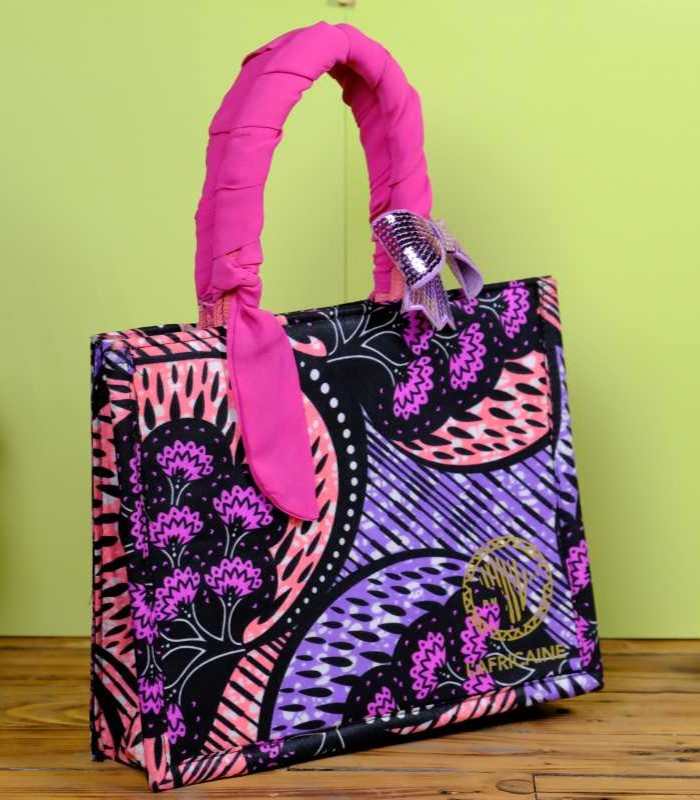 Ankara star sequin handbag 1 ankara star sequin handbag in pink and blue Ankara wax fabric with bold star motifs, padded handles, solid frame, and shimmering sequin bow.